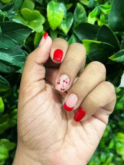 A playful and modern take on the classic French manicure. This design features vibrant red tips paired with a cute, hand-painted cherry accent nail for a fun pop of color.