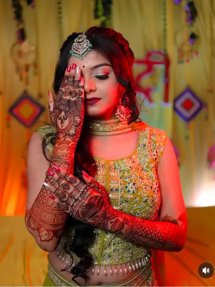 A classic bridal pose, with the bride's henna-covered hands gently framing her face.
