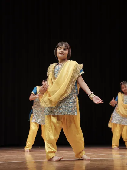 A 'Dancing Divaa' in a traditional Punjabi outfit, mid-performance at THIRKAN.