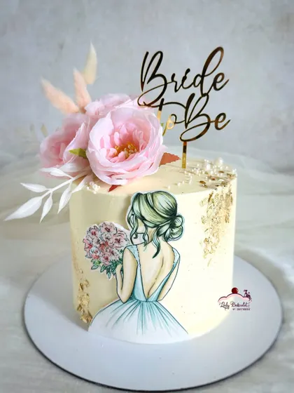 A beautiful cake for a bride-to-be. This design features a hand-painted illustration on edible paper, surrounded by delicate florals and gold leaf.