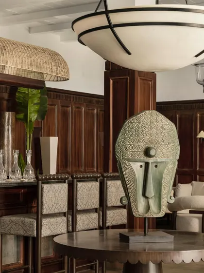 A curated corner in the Lord Elgin lounge, where a tribal mask sculpture sits on a modern console table. This juxtaposition of artifacts and contemporary forms against a backdrop of traditional wood paneling is a signature of the space.