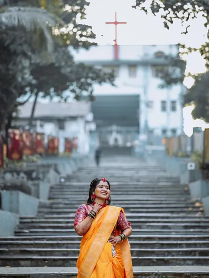 A wide shot of the bride at her Haldi ceremony, with a church in the background.