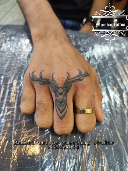 A unique deer head finger tattoo. This is a challenging placement, but our artists have the precision to create detailed and striking designs even on a small scale.