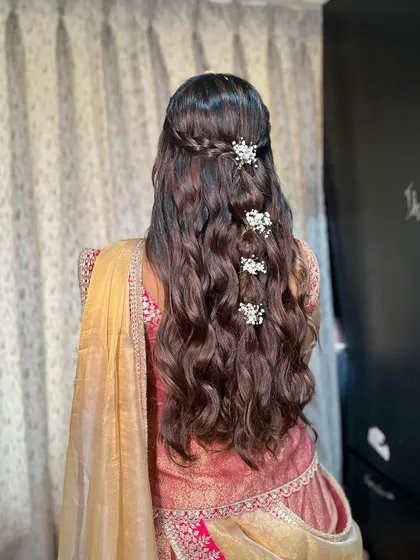 A detailed shot of Jhanvi's beautiful hairstyle for her Mandap Mahurat, featuring soft waves and delicate pearl accessories.