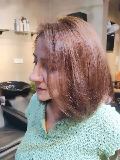 Experience the magic of transformation at our salon. This client is enjoying her fresh new haircut and color.