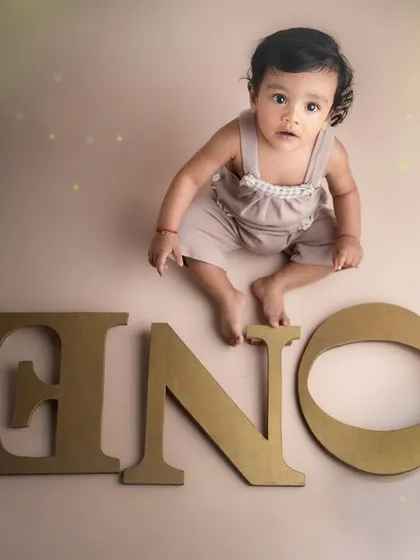 A creative flat-lay style shot for a first birthday. Having the baby sit among the letters is a fun and unique way to capture this special "ONE" year milestone.