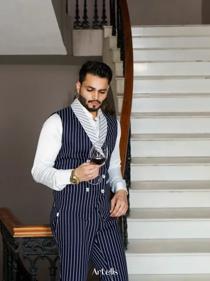 Another shot from the Artells Magazine feature, capturing a sophisticated moment with a glass of wine. The pinstripe suit and elegant setting fit the theme perfectly.