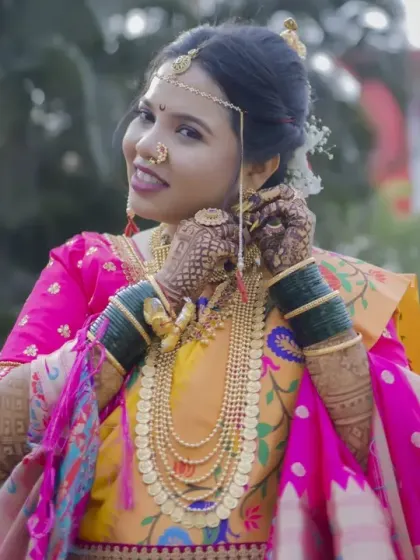 The bride adjusts her traditional headpiece, a beautiful candid moment that showcases her intricate jewelry and happy expression.