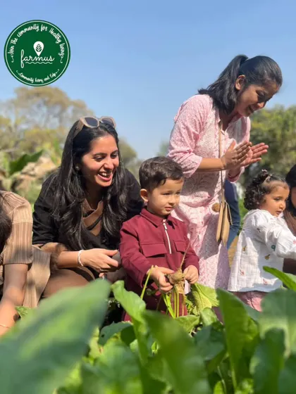 The joy of discovery. A group of children and adults are all smiles as they explore the vegetable patches and learn about organic farming together.
