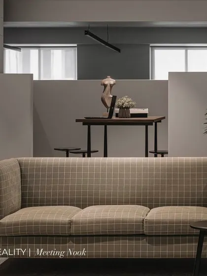 From vision to reality. This image shows the meeting nook in an office we designed, where a checkered green couch and a semi-open half-wall create a space that is both connected and private.