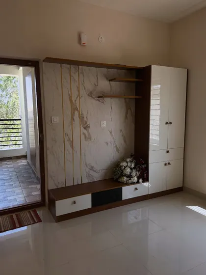 A full view of a living room project from different angles. We painted the walls in a neutral beige that pairs well with the white and wood entertainment unit, creating a warm and modern feel.