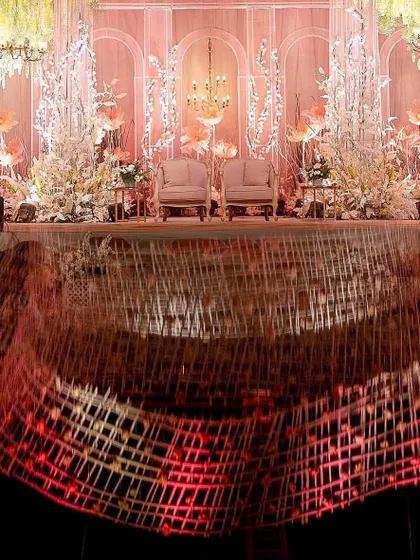 The main stage viewed over the reflective surface, creating a mirror image of the entire setup. This highlights the interplay of light and reflection that was central to the event's design concept.