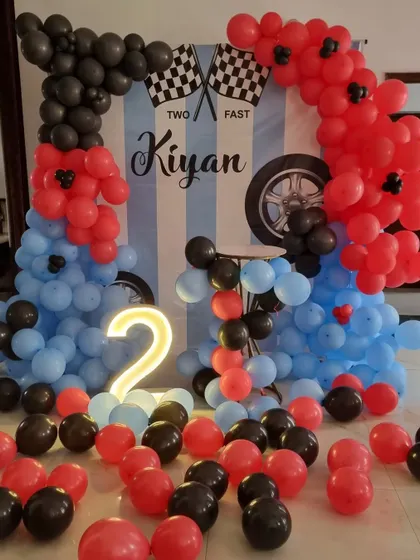 A wide shot showing the balloons scattered on the floor, adding to the fun and immersive feel of the car-themed party.