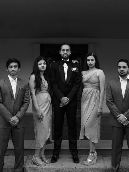 A classic black and white portrait of the groom with his groomsmen and bridesmaids, looking sharp and elegant for the reception.