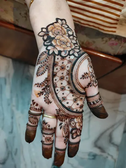 This elegant design combines a floral bunch at the top with a delicate net pattern on the palm, a style often requested for parties and engagements.