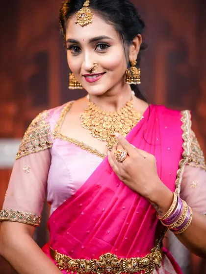 A close up look at our jewellery styled with a beautiful pink half saree. This matt gold finish choker, maang tikka, and jhumkas are perfect for pre wedding events, puberty ceremonies, or for bridesmaids.