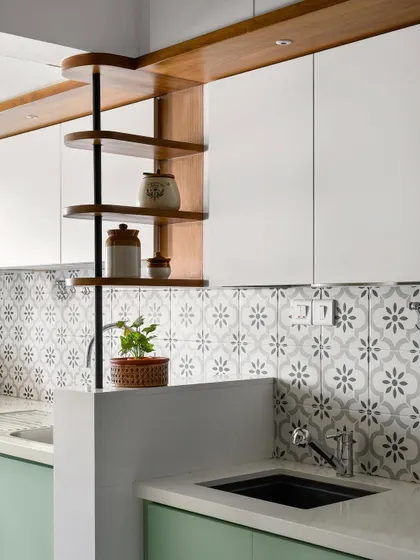 This kitchen design features a beautiful interplay of mint green cabinets, patterned tiles, and a custom wooden rotating shelf.