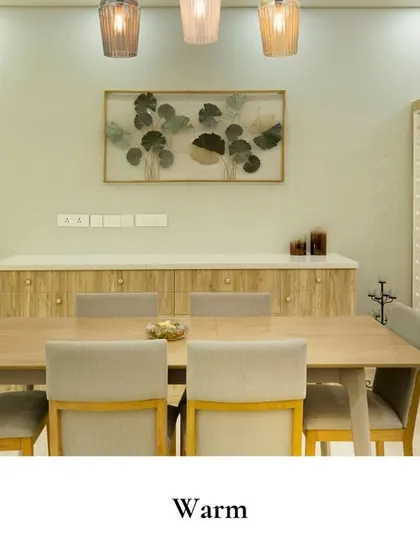 The wooden textures, calming neutrals, and soft pendant lights add warmth to this dining area. The intricately designed pooja nook seamlessly introduces a touch of cultural grace into the modern space.