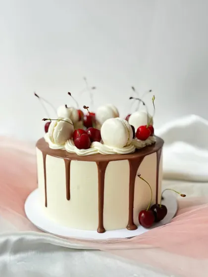 A classic combination of chocolate, cherry, and vanilla. This drip cake is generously topped with fresh cherries and macarons, perfect for any celebration.