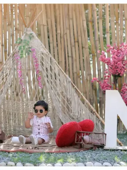 A wide shot of our outdoor boho first birthday setup, showcasing the full scene with a teepee, 'ONE' letters, and beautiful floral details.