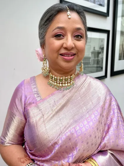 This mother of the bride is radiant in a beautiful lavender silk saree. The makeup is soft and pink-toned to complement her outfit.