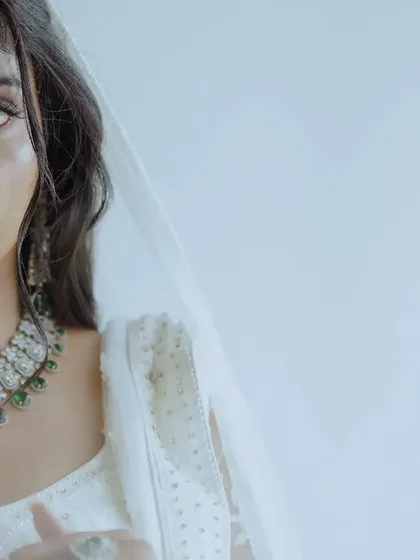 A striking half-face portrait of a bride, creating a sense of mystery and highlighting her beautiful eyes and jewelry.