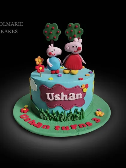 A cheerful Peppa Pig and George cake for a 3rd birthday. The fondant figures are set in a playful scene with trees, flowers, and a grassy field.
