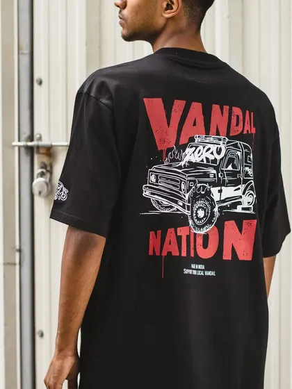 Another lifestyle shot of the 'Vandal Nation' T-shirt against an industrial background, highlighting its street-style aesthetic.