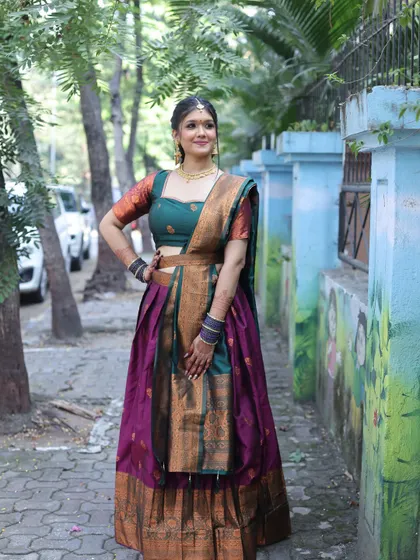 A full-length shot of a client in a traditional South Indian half-saree. The makeup is classic and elegant, perfect for the occasion.