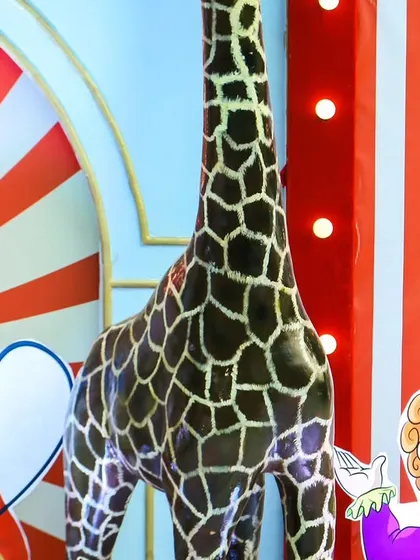 A close-up of the detailed props, including a tall giraffe and clown cutouts, that helped create an authentic carnival feel.
