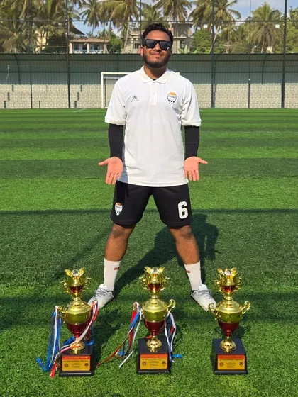 One of our dedicated coaches, Mohit Singh, posing with trophies won at a tournament. Our coaches are passionate and committed to success.