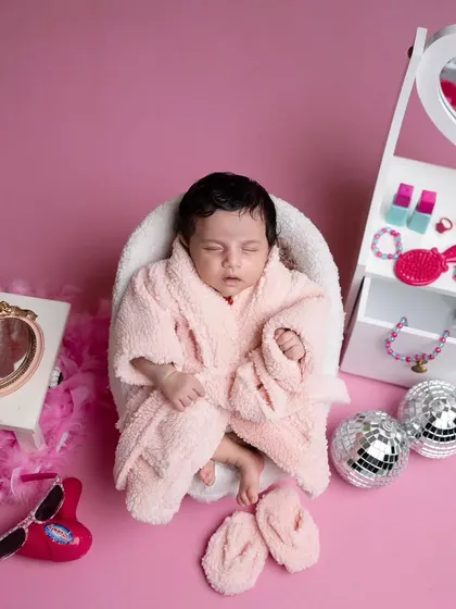 A pampering spa day for this little beauty. Dressed in a fluffy pink bathrobe, she's surrounded by a miniature vanity, disco balls, and other fun, girly props.