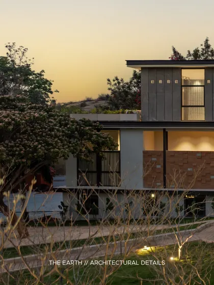The building's profile against the sunset. The multi-level design, featuring a mix of plaster, stone, and large windows, is composed to create a visually interesting form that changes with the light throughout the day.