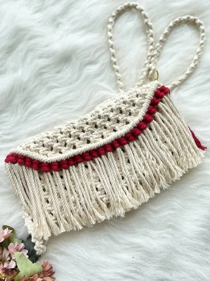 This sling bag combines a natural cream color with a simple red accent along the fringed flap, creating a subtle yet stylish look.