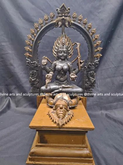 The wax model for a sculpture of Kalika, a powerful form of Goddess Kali. She is depicted seated upon a symbolic figure, with a Prabhavali arch behind her, all sculpted from wax.