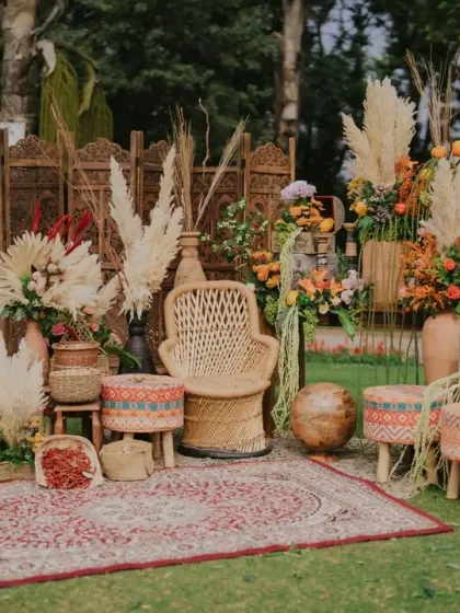 A styled photo corner at the Marrakesh Mehendi, featuring a carved wooden screen, rattan chair, and a collection of textured poufs and carpets.