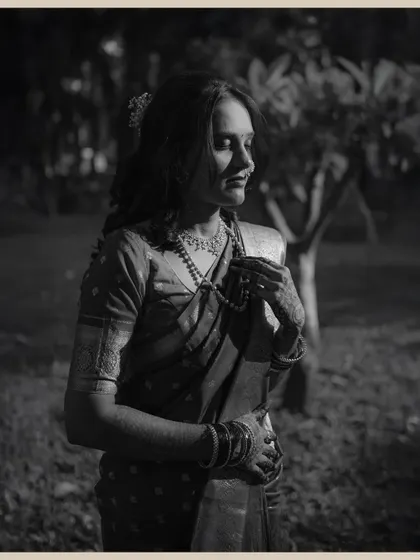 A moody, black and white portrait of the bride in a quiet, contemplative moment. The dramatic lighting creates a beautiful, artistic feel.