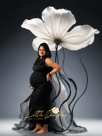 Simple, elegant, and striking. The contrast of the black gown against the giant white flower prop creates a modern and artistic maternity portrait.