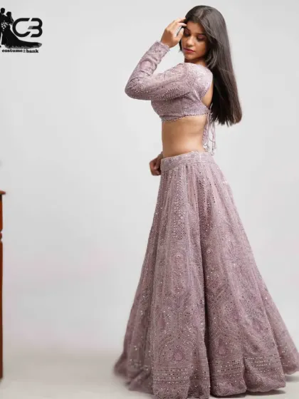 A full-length side view of the lavender sequin lehenga, highlighting its flowing skirt and backless top design.