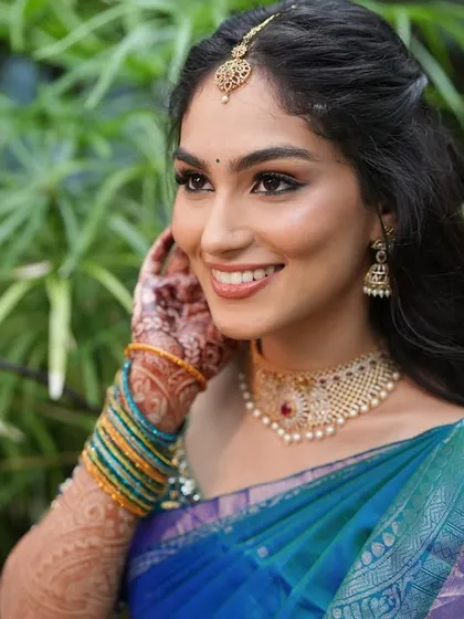 A close-up smile that says it all. The dewy makeup and soft pink lips give her a fresh and youthful glow for her engagement day.