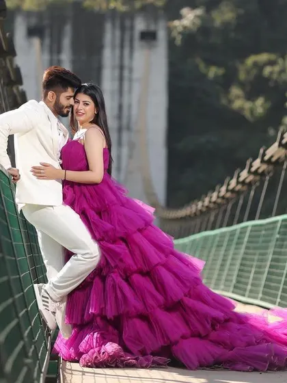 A stunning portrait on a suspension bridge in Rishikesh, with the bride's magnificent ruffled gown creating a dramatic and fashionable statement. This shot perfectly balances the couple's style with the rugged beauty of the location.