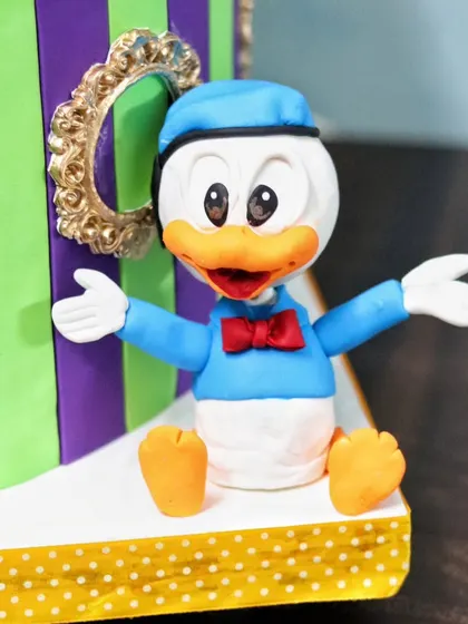 A cheerful Donald Duck figurine, part of a larger Disney-themed cake. I teach how to capture the classic look of these beloved characters.