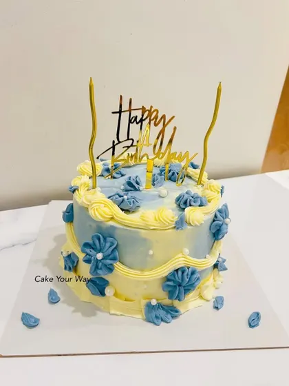 Buttercream dreams and birthday beams. A vintage-style cake in blue and yellow with delicate floral piping.