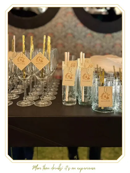 A collection of elegant glassware prepared with custom tags and stirrers, ready for service.