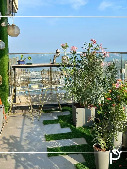 This sea-facing balcony is designed to withstand the elements while providing a beautiful view. We used hardy plants like Oleander in modern planters, combined with artificial turf stepping stones for a practical and stylish finish.
