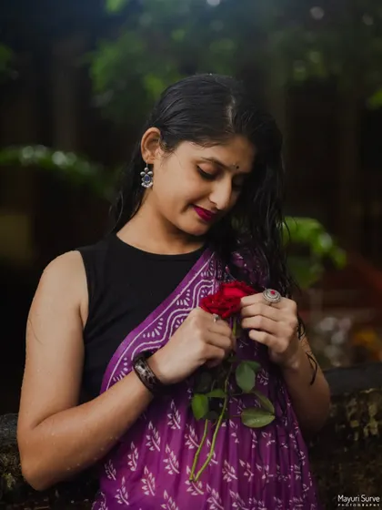 A close-up portrait with a single red rose. The model's gentle expression and the soft lighting create a romantic and intimate mood, perfect for capturing personal stories.