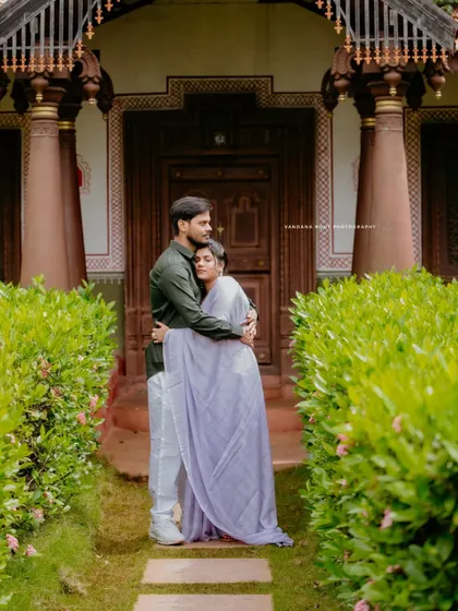 An intimate embrace between a couple outside a traditional home, capturing the blend of romance and cultural heritage.