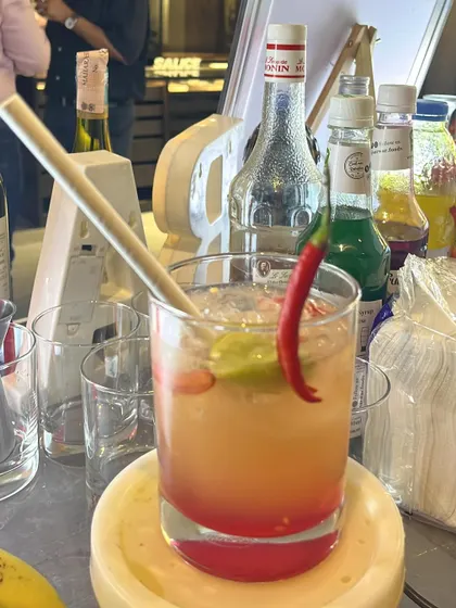 A spicy, layered cocktail with a red chili garnish. We love creating drinks that are bold and full of character.