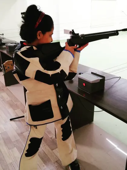 One of our younger athletes in her shooting suit, learning the fundamentals of air rifle handling and safety at our range.