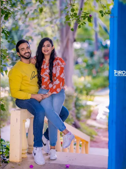 A relaxed and happy portrait of a couple on a balcony. Their casual outfits and the bright blue door create a fresh and modern look.